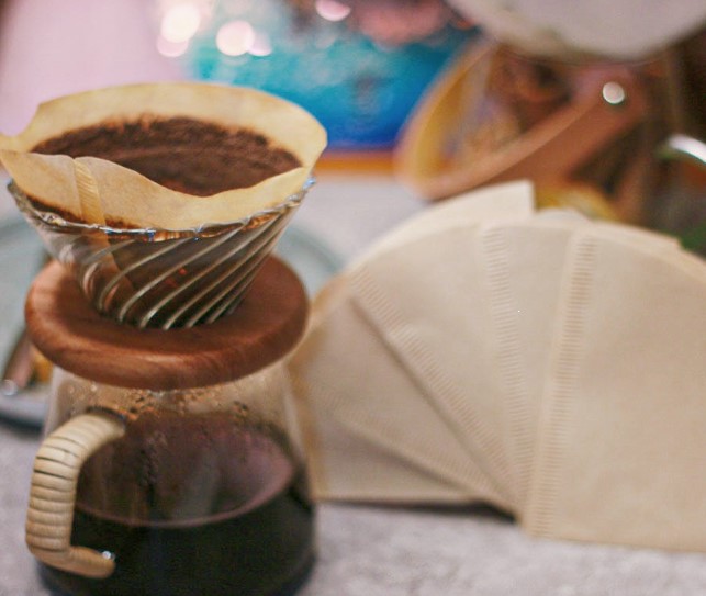 How does wet filter paper affect the flavor of hand-brewed coffee?